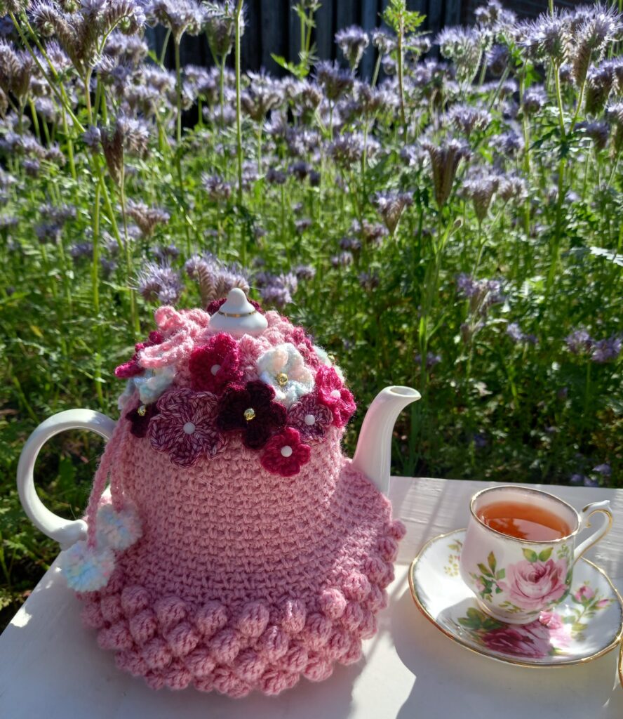 Theepotwarmer versierd met bloemetjes en thee